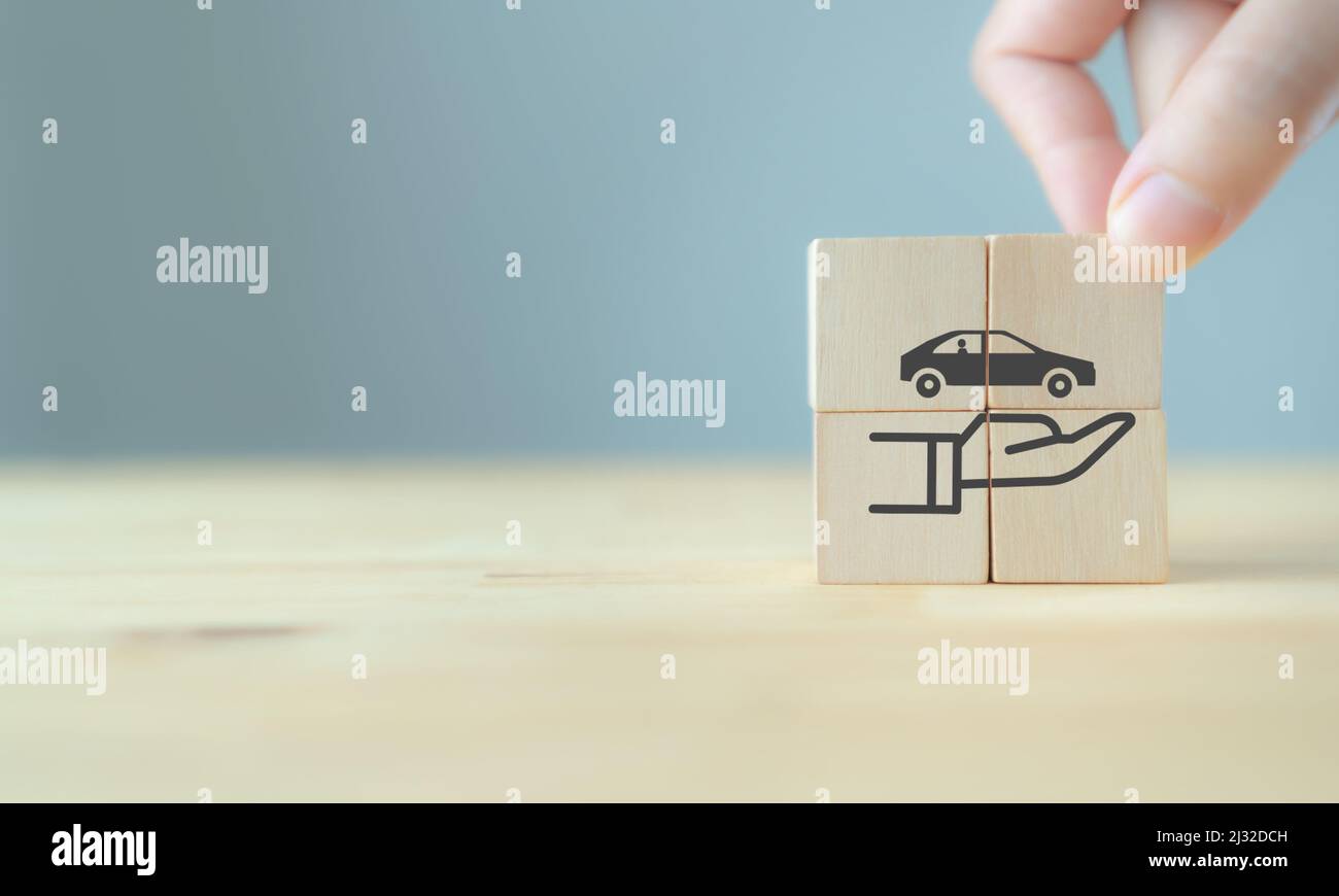 Assicurazione auto (automobile) e concetti di esonero da collisione danni. La mano tiene i cubetti di legno con il simbolo di protezione di cura su sfondo grigio e copia Foto Stock