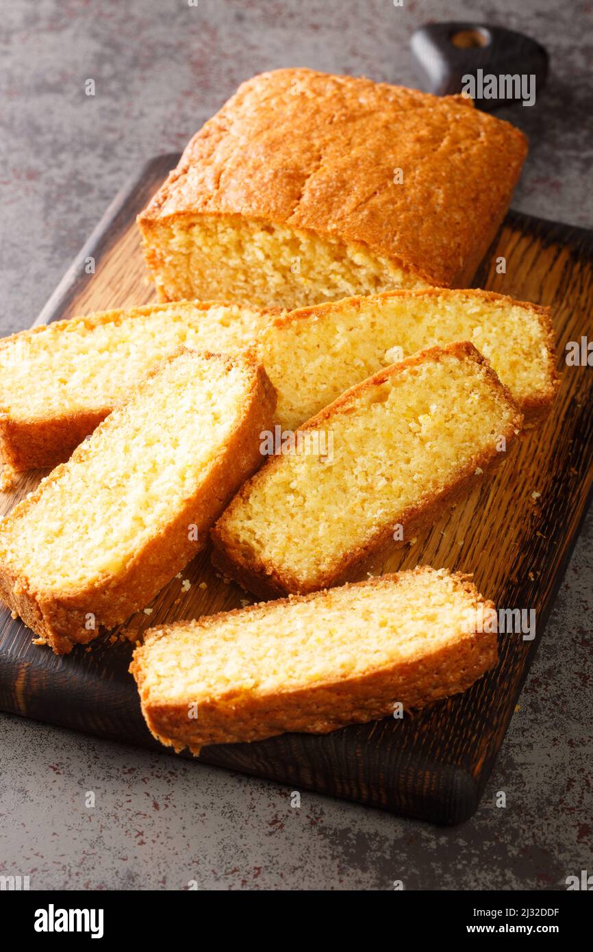 Pane normale di torta di sterlina madeira su un tagliere di legno sul tavolo. Verticale Foto Stock