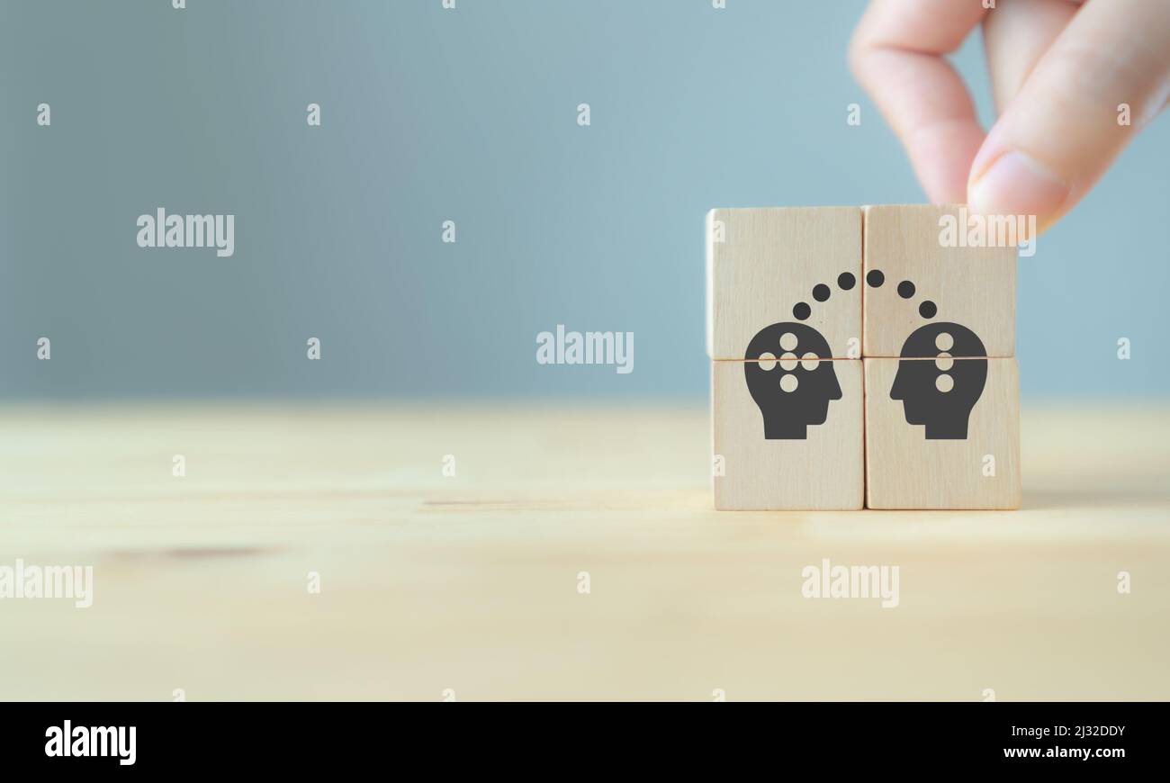 Conoscenza e idee condivisione tra due persone testa icona su cubo di legno. Trasferire conoscenza, innovazione, concetto di brainstorming. Strategia aziendale Foto Stock