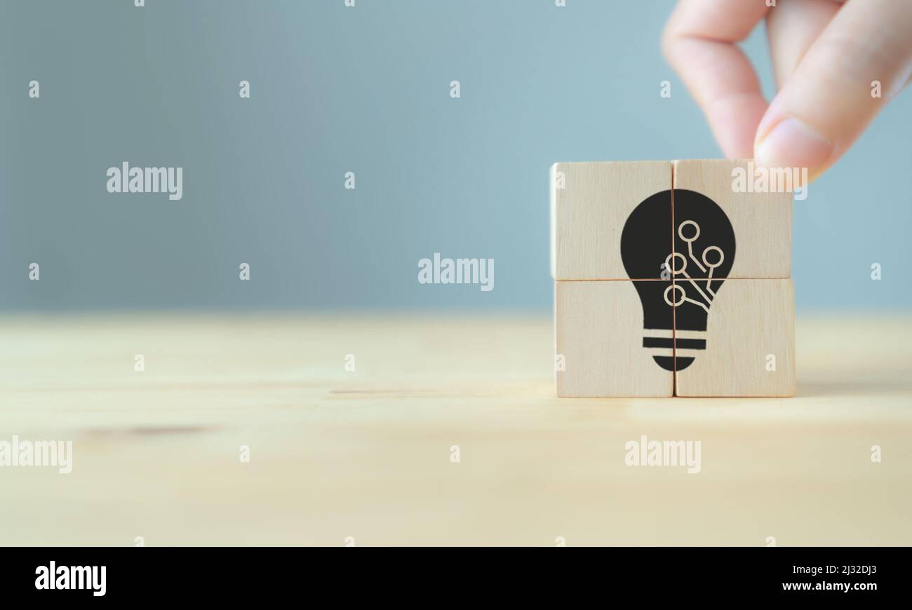 Idee di innovazione e concetto tecnologico. Prodotto e servizio ad alto valore aggiunto per la strategia aziendale. Mano mette i cubetti di legno; lampadina con te Foto Stock