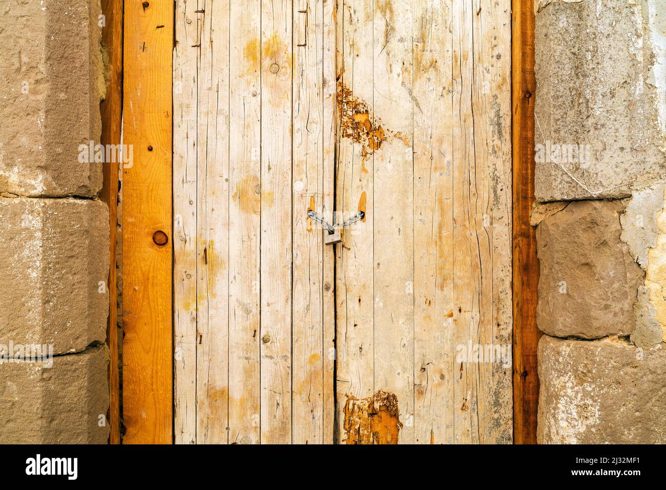 Lucchetto arrugginito che blocca la vecchia porta di legno con una catena, Tavira, Portogallo Foto Stock