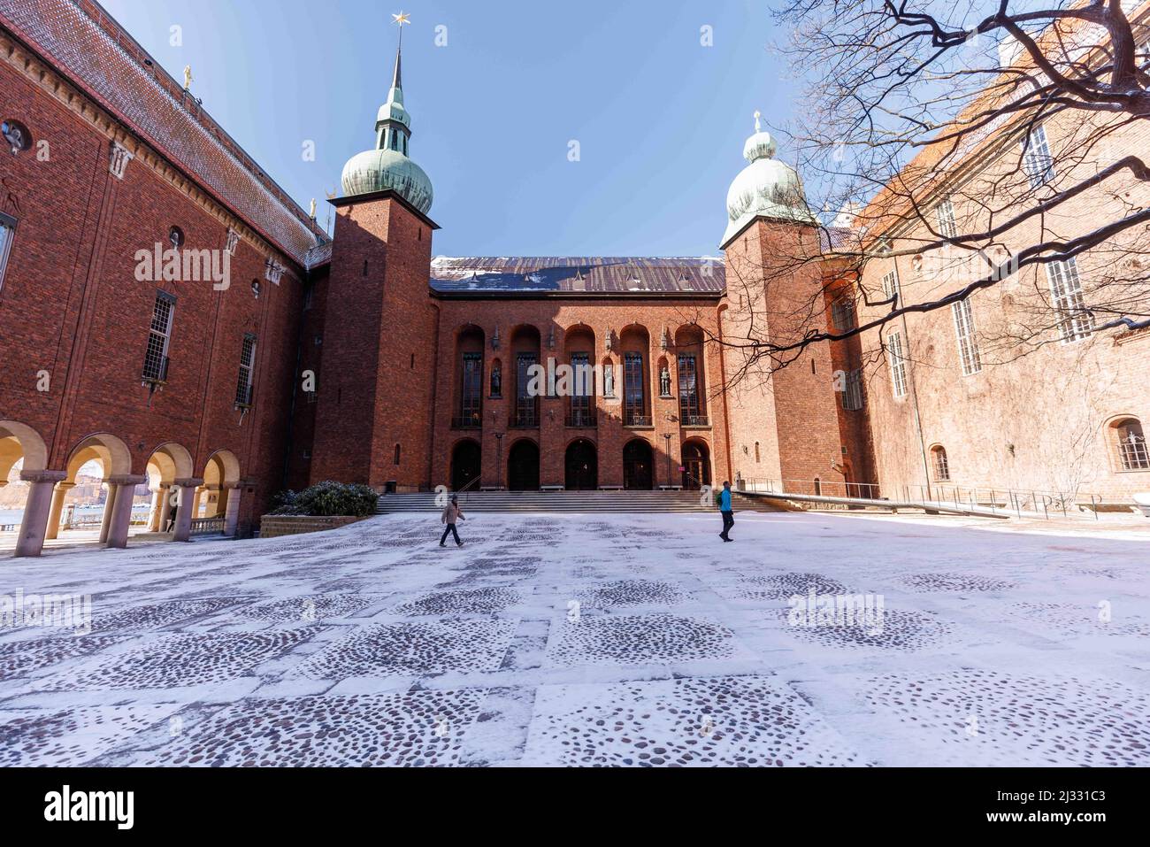 (220405) -- STOCCOLMA, 5 aprile 2022 (Xinhua) -- persone camminano nel cortile interno del municipio di Stoccolma dopo la neve a Stoccolma, capitale della Svezia, 5 aprile 2022. Una nevicata ha colpito la Svezia a fine lunedì sera, coprendo edifici con un velo di neve scintillante e chiaro nella primavera nordica. (Foto di Wei Xuechao/Xinhua) Foto Stock