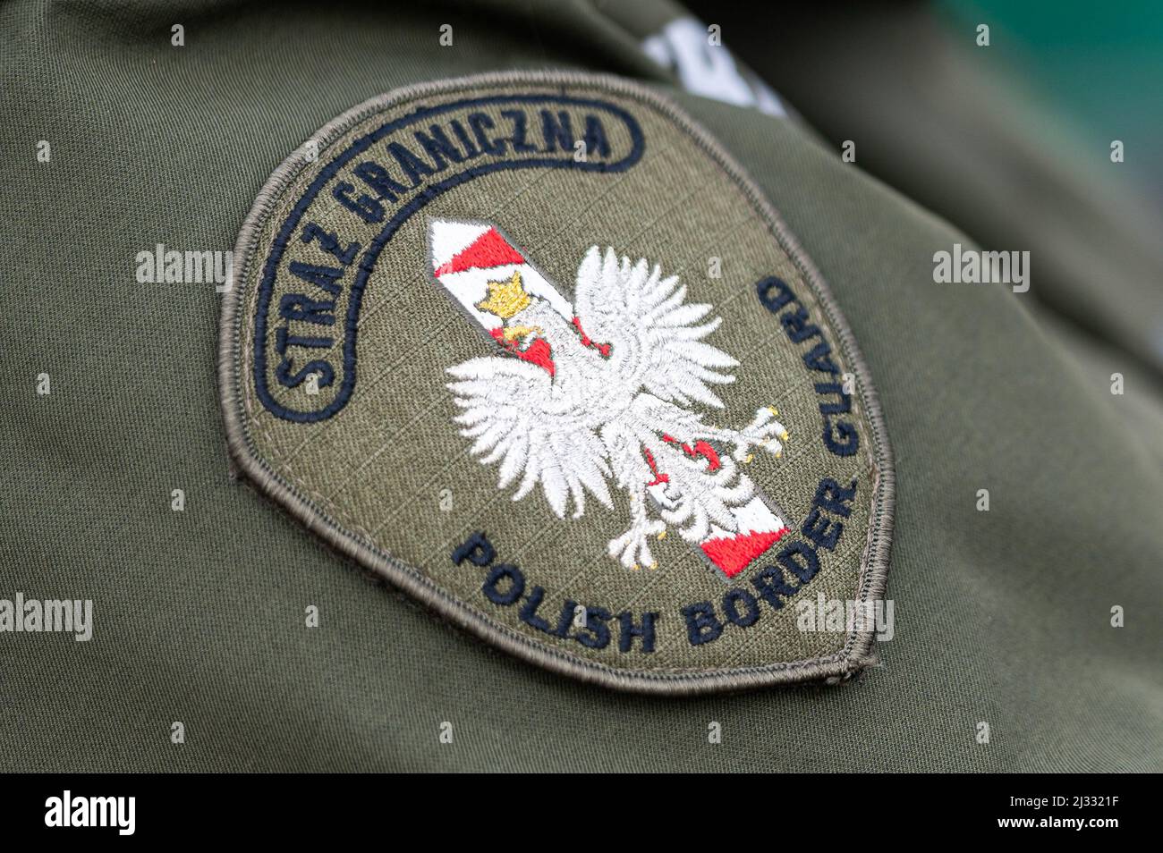 Un emblema del polacco visto sull'uniforme di una Guardia di confine polacca al valico di frontiera a Grzechotki. La Russia ha invaso l'Ucraina il 24 febbraio 2022, scatenando il più grande attacco militare in Europa dalla seconda guerra mondiale Fino a 10 milioni di ucraini sono fuggiti dalle loro case, lasciando il paese o trasferendosi in aree più sicure all’interno dell’Ucraina. Si ritiene che circa 3 milioni di rifugiati abbiano attraversato i confini verso i paesi vicini. Foto Stock