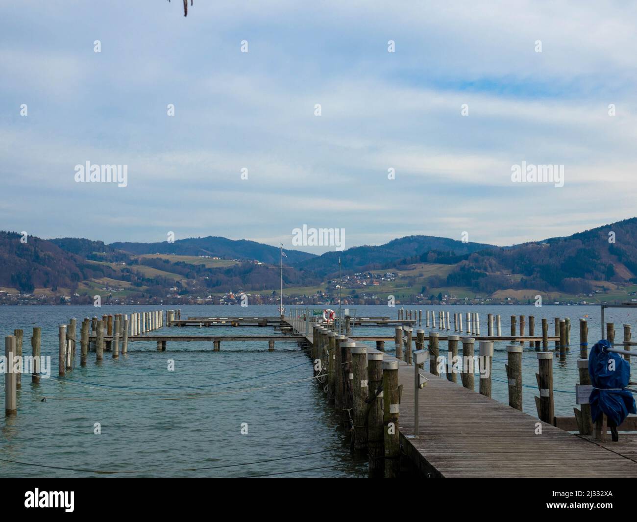 Vista panoramica sul lago Attersee con molo in legno e catena montuosa sullo sfondo. Salzkammergut Austria superiore Foto Stock