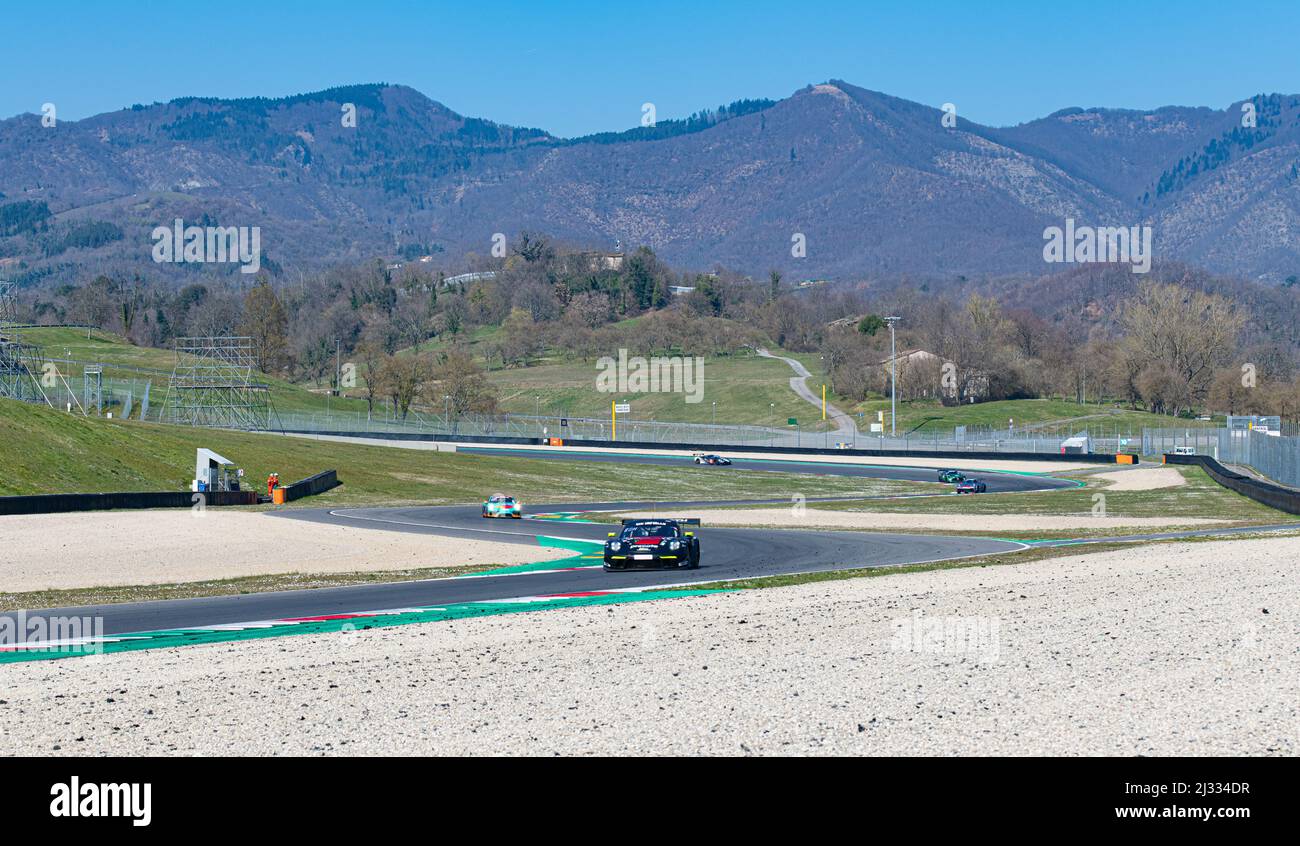 Vista paesaggio di auto da corsa su asfalto pista verde collina e sfondo campo. Circuito del Mugello, Italia, marzo 25 2022. Serie 24 ore Foto Stock