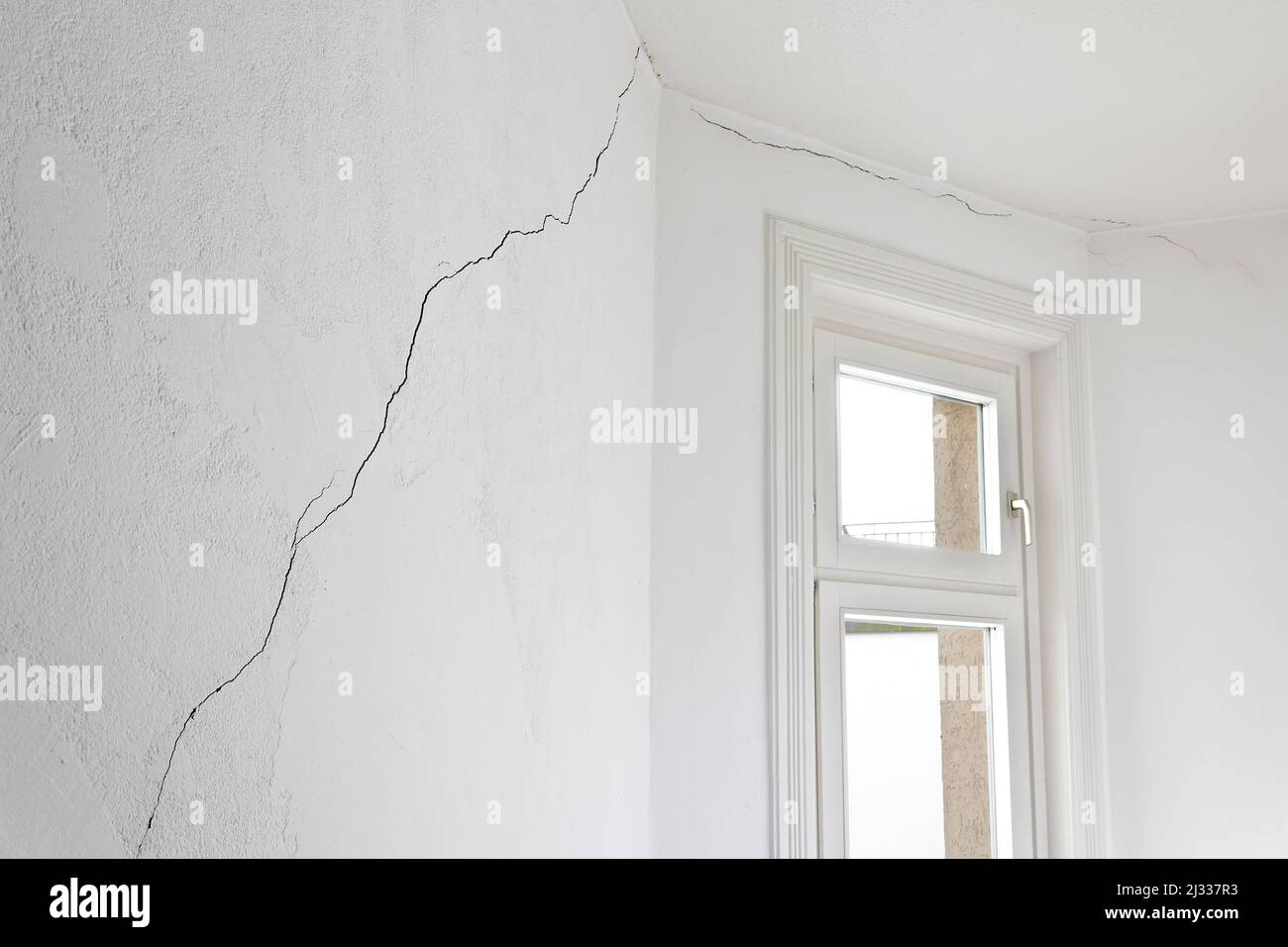 Concetto di danno edilizio: Crepa molto lunga nel muro di un appartamento o appartamento in una vecchia casa, causata da un terremoto o frana. Foto Stock