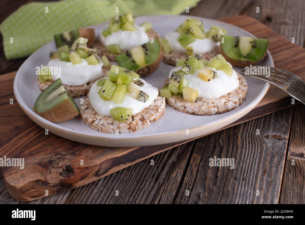 Sana proteina fitness prima colazione o snack con cracker di riso marrone. Sormontato da gracelo islandico e kiwi tritati Foto Stock