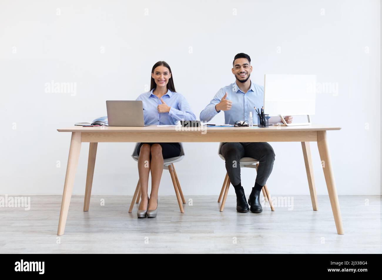 I colleghi che lavorano in ufficio sono felici di mostrare le miniature in alto Foto Stock