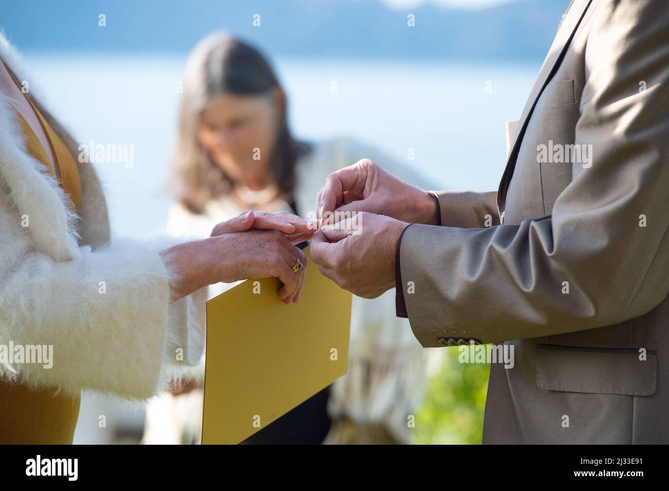 Sposi e sposi più vecchi durante la loro cerimonia nuziale mentre groom che mette l'anello sul dito della sposa. Sposarsi di nuovo. Sposato ancora una volta. Foto Stock