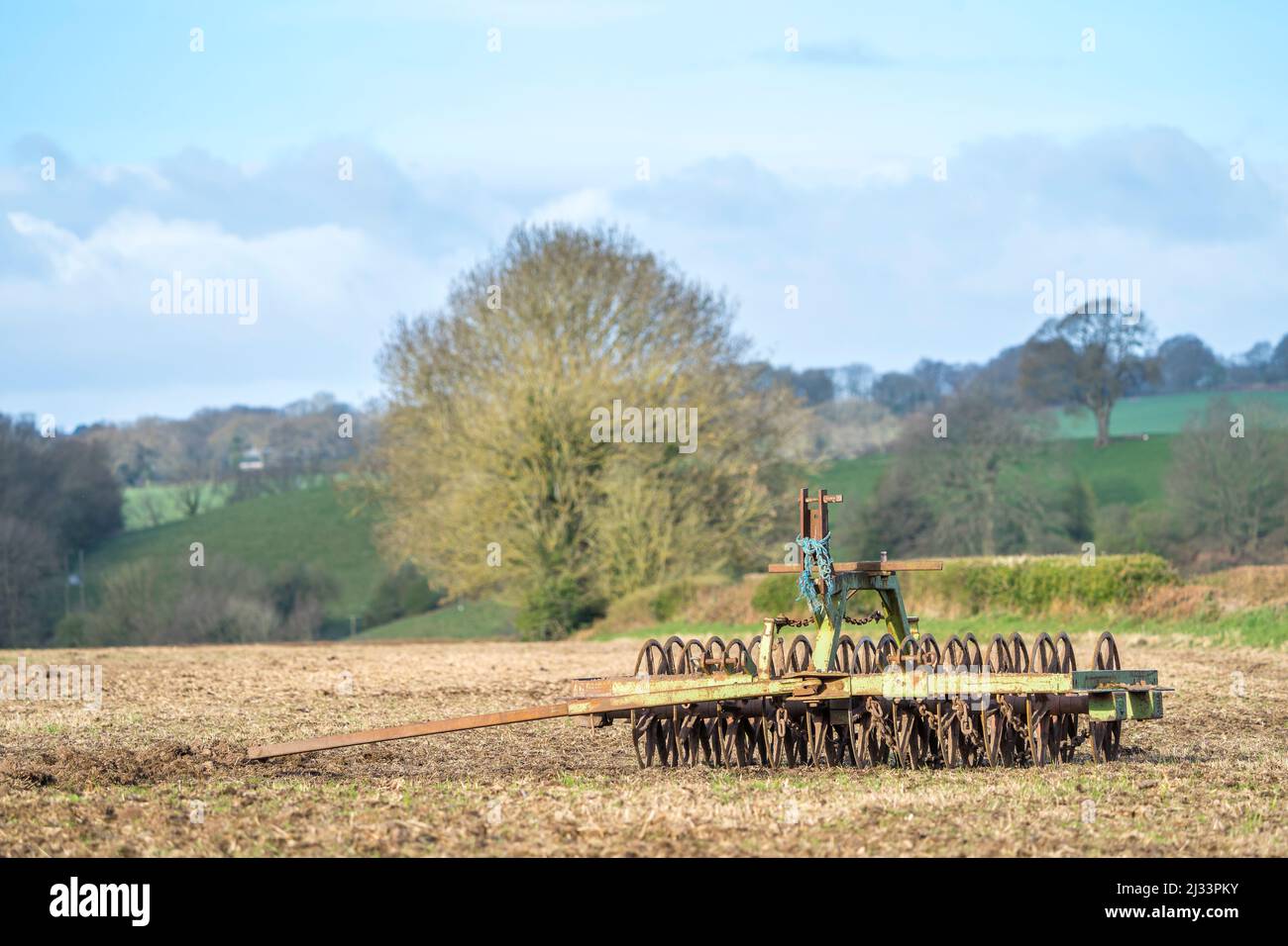 Un rastrello di terra meccanico degli agricoltori. Macchine agricole britanniche all'aperto in un campo. Foto Stock