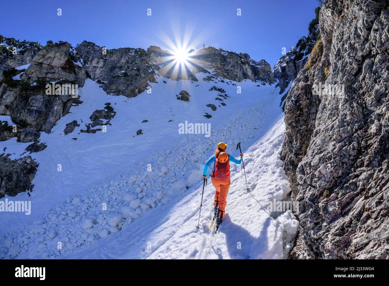 La donna in giro per lo sci sale attraverso un ripido burrone fino a Predigtstuhl, Alpgartenrinne, Predigtstuhl, Lattengebirge, Alpi Berchtesgaden, Baviera superiore, Baviera, Germania Foto Stock