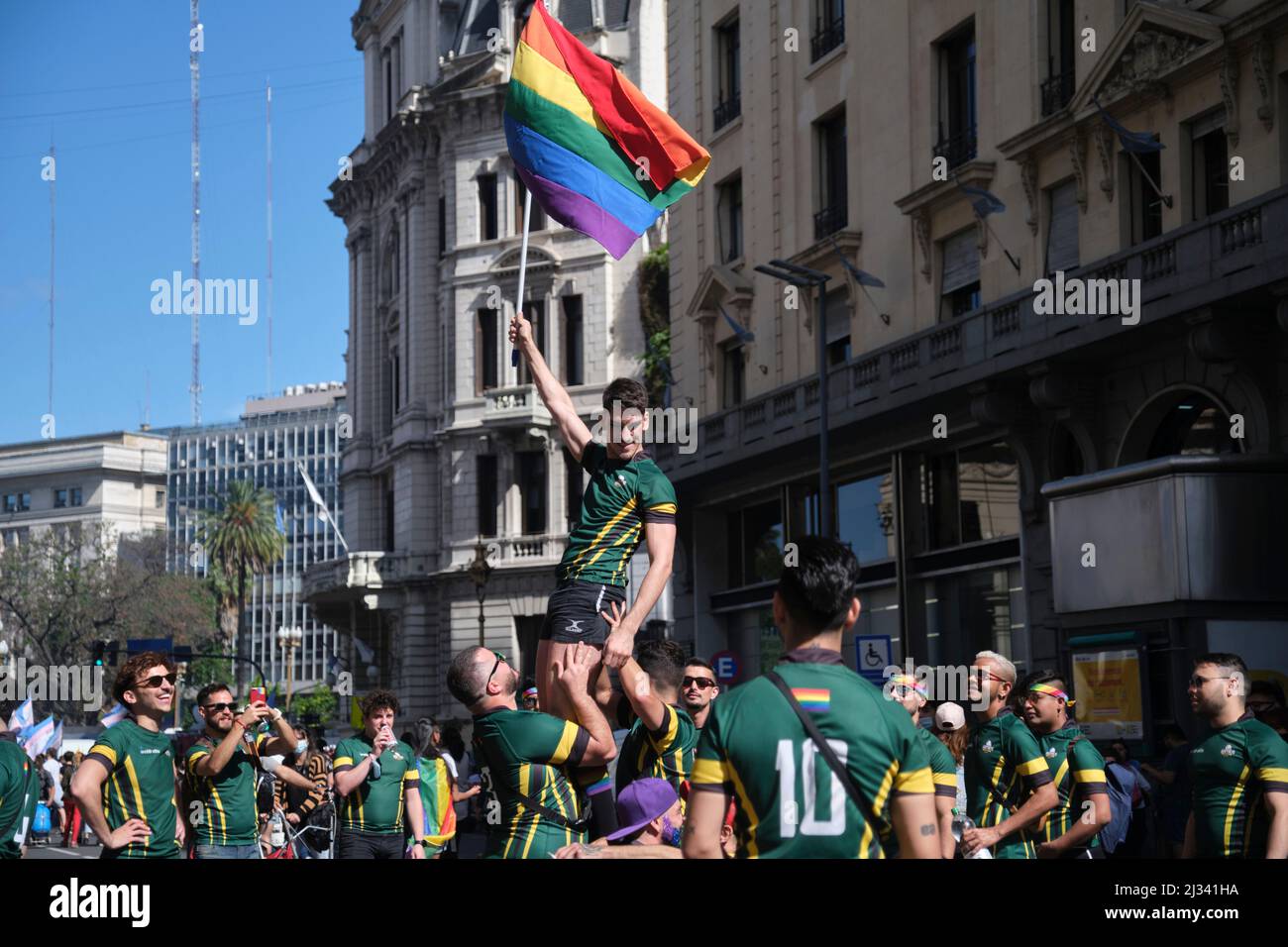 Buenos Aires, Argentina; 6 novembre 2021: LGBT Pride Parade. Gruppo di giovani uomini che sollevano uno di loro tenendo la bandiera dell'arcobaleno, simbolo della LGBT+ commu Foto Stock