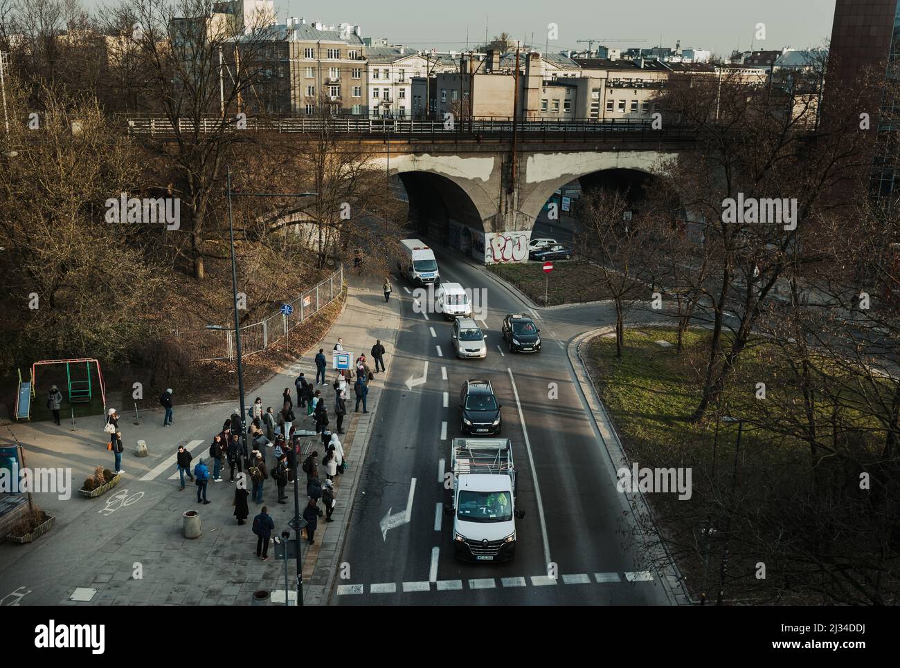 Varsavia. Polonia. 03.30.2022. Traffico stradale. Una macchina dopo l'altra si fermò di fronte ad un passaggio pedonale. La gente alla fermata dell'autobus sta aspettando il Th Foto Stock