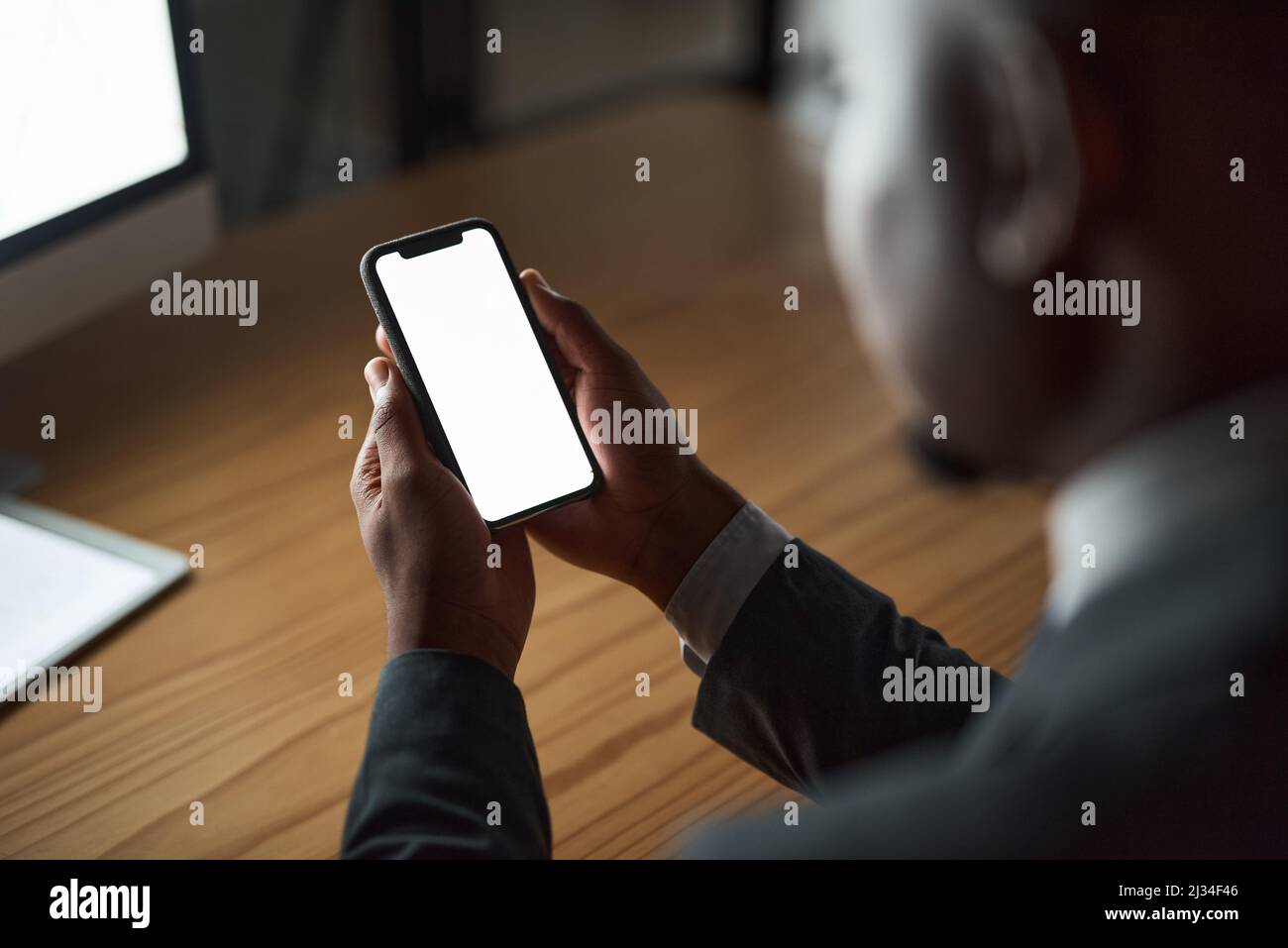 Lavorare un doppio turno stasera. Scatto ritagliato di una persona irriconoscibile utilizzando il telefono in ufficio. Foto Stock