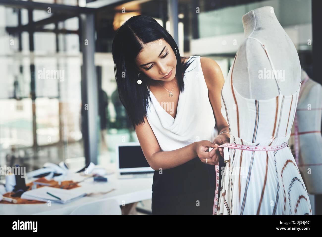 Il malato deve prendere alcuni pollici fuori. Scatto di un giovane fashion designer di successo che lavora al suo ultimo design. Foto Stock