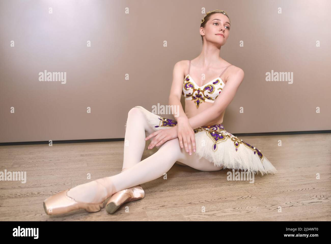 giovane bella bella ballerina caucasica pratica posizioni balletto in gonna tutu. Ballerino classico in studio Foto Stock