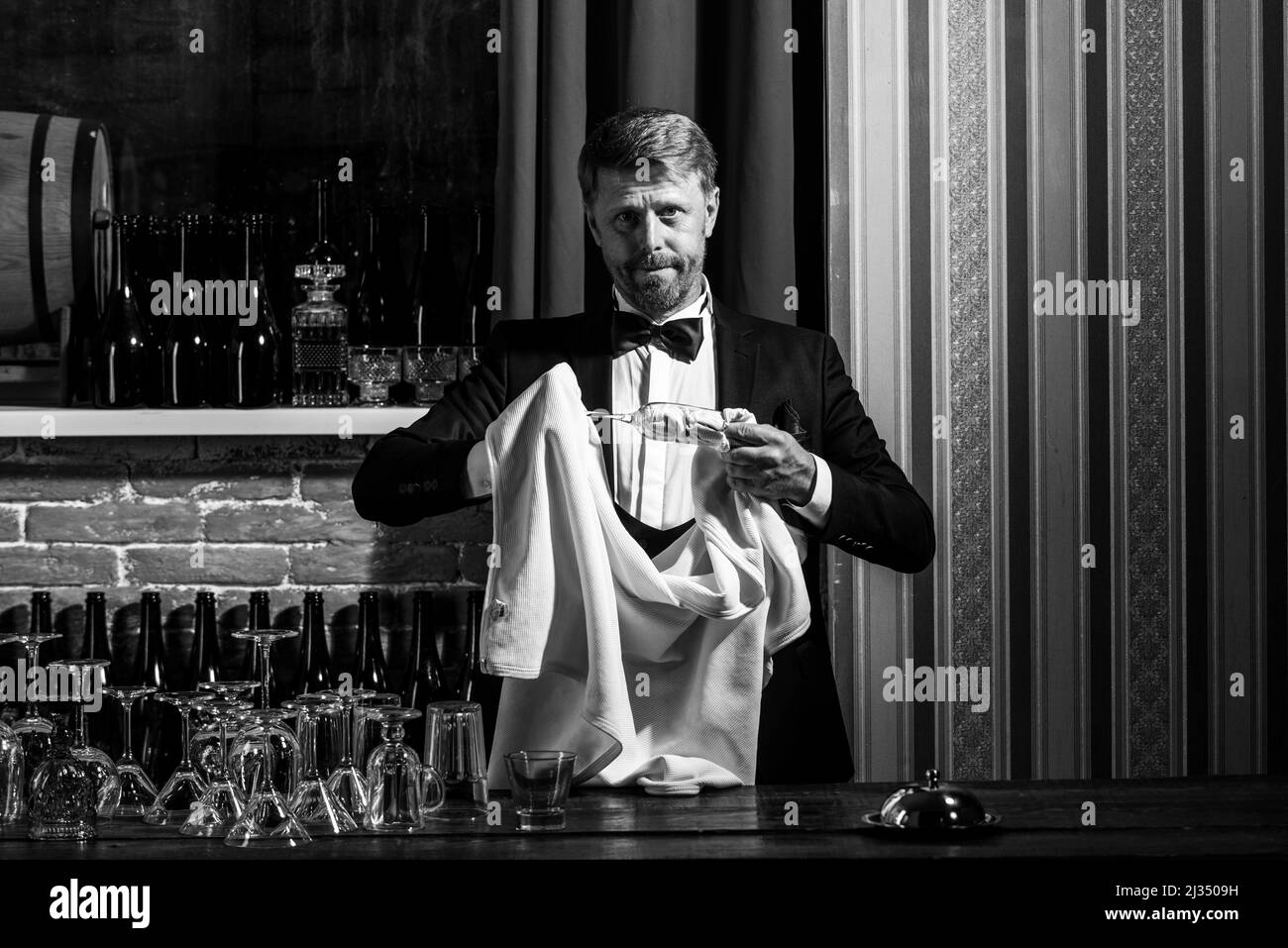 Vetro pulito per barman. Il personale del ristorante pulisce. Cameriere barman strofinare vetro. Servizio di bevande alcoliche. Foto Stock