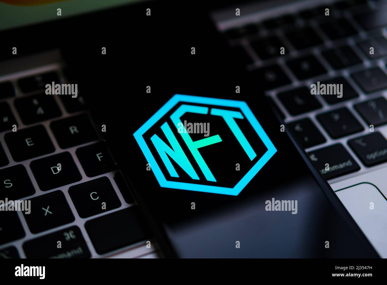 Logo NFT visualizzato sullo smartphone posizionato sulla tastiera del computer portatile. Messa a fuoco selettiva. Concetto. Stafford, Regno Unito, 5 aprile 2022 Foto Stock