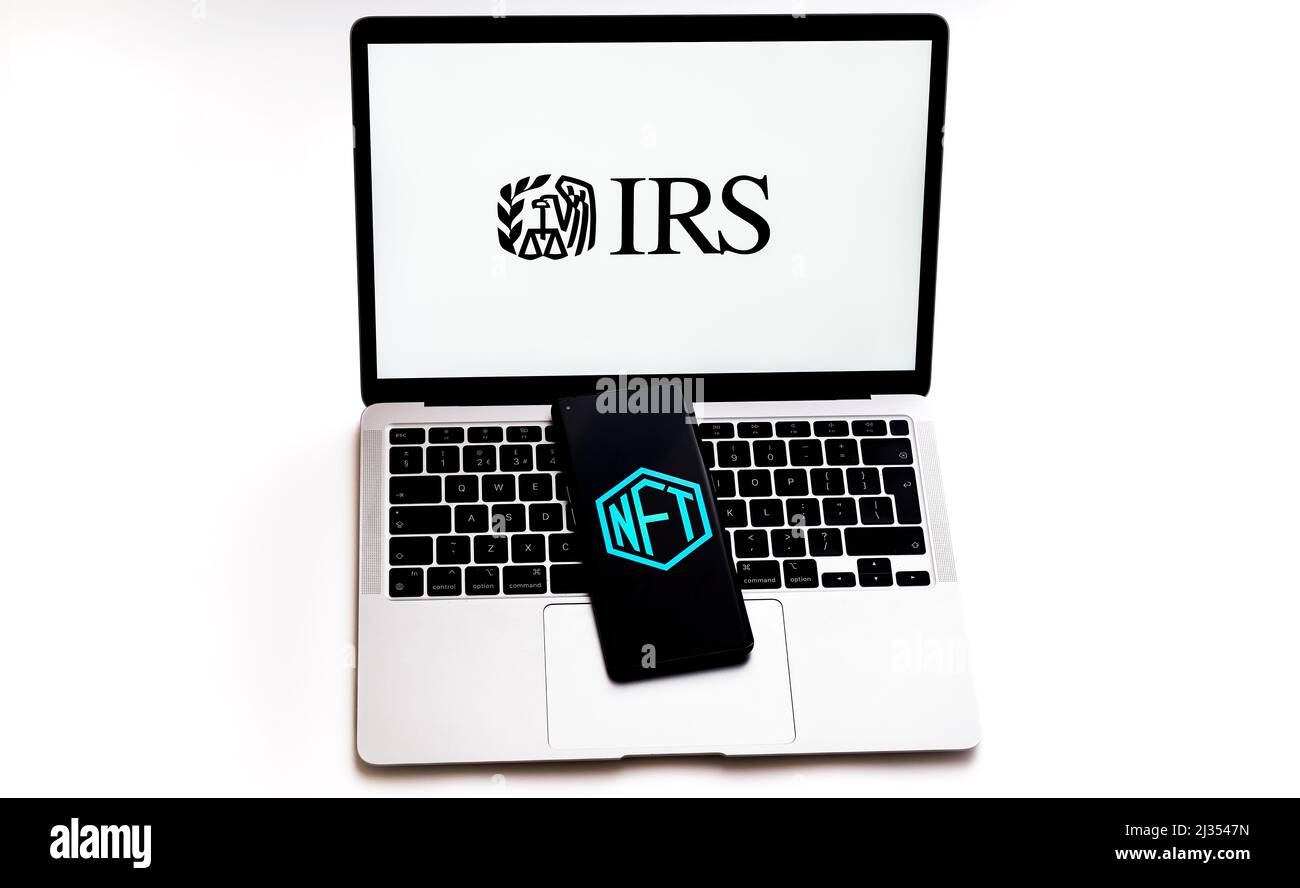 Logo NFT visualizzato sullo smartphone posizionato sulla tastiera del laptop con logo IRS. Messa a fuoco selettiva. Concetto. Stafford, Regno Unito, 5 aprile 2022 Foto Stock