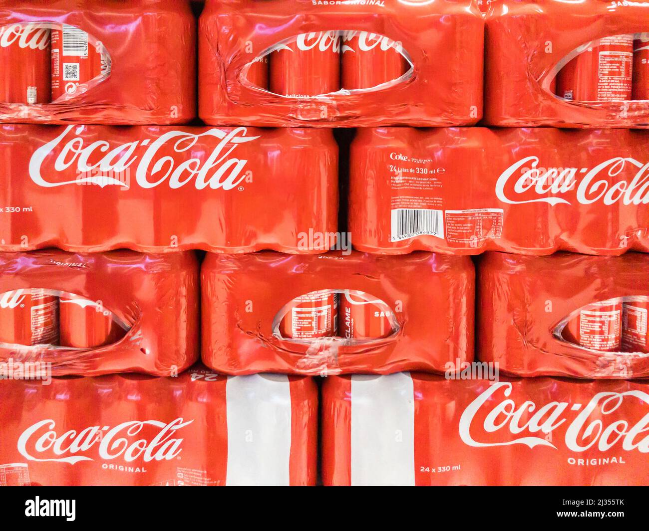 Coca Cola lattine imballate con plastica e immagazzinate in un supermercato. Foto Stock