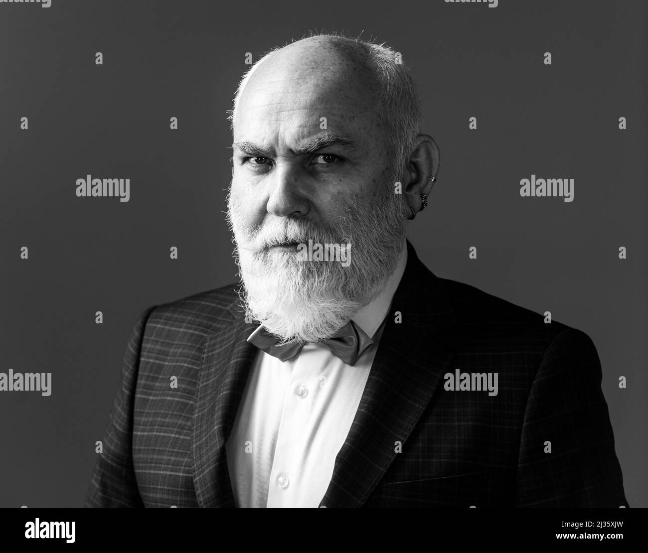 Uomo anziano serio. Uomo di mezza età con un'espressione seria in un ritratto della testa e delle spalle del closeup. Foto Stock