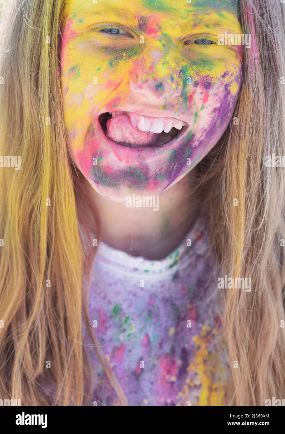 Passatempo spensierato. Vita felice nel tempo adolescente. Campeggio vacanze. Ragazza emozionale con umore felice con colori asciutti colorati. Holi colorati sul viso dipinto Foto Stock