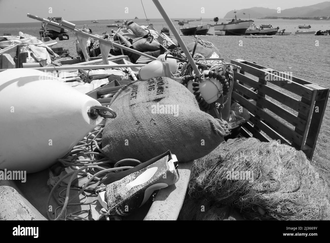 Una foto in scala di grigi di attrezzatura da pesca tradizionale su una barca Foto Stock