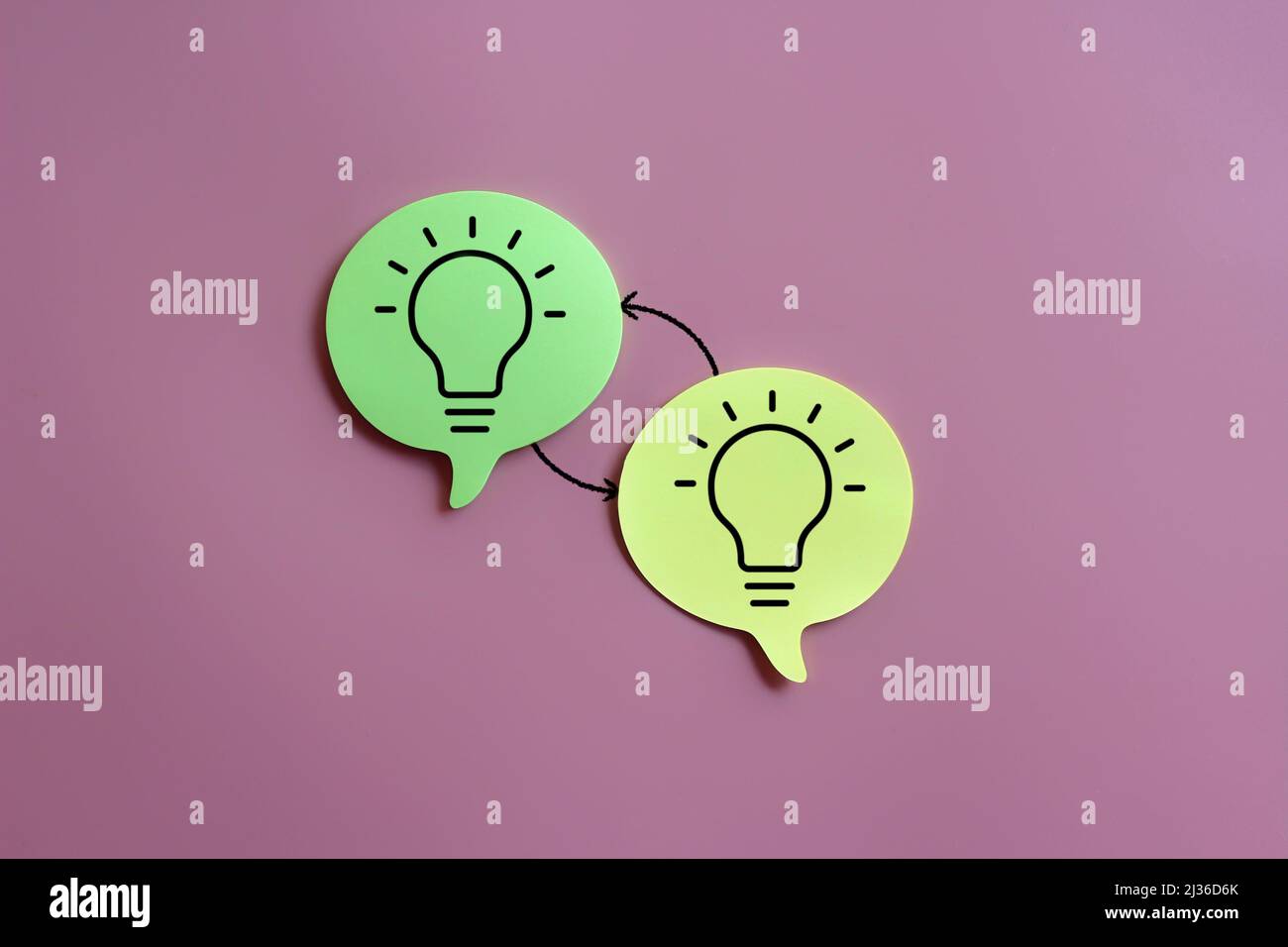 Icona a forma di lampadina sul fumetto vocale e freccia di scambio su sfondo rosa. Scambio di idee, brainstorming Foto Stock