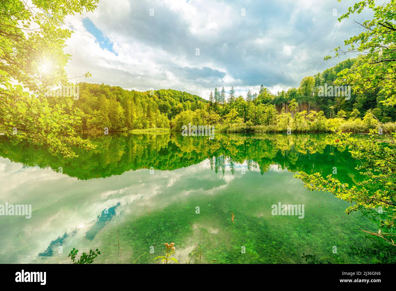 Il sole sulla cascata di Veliki Prstavac si riflette nel lago Potok Plitvice del Parco Nazionale di Plitvice in Croazia. Patrimonio mondiale dell'UNESCO della Croazia Foto Stock