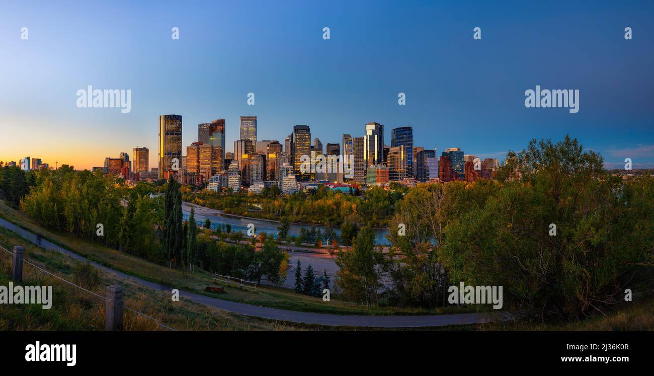 Tramonto sopra lo skyline della città di Calgary con il fiume Bow, Canada Foto Stock