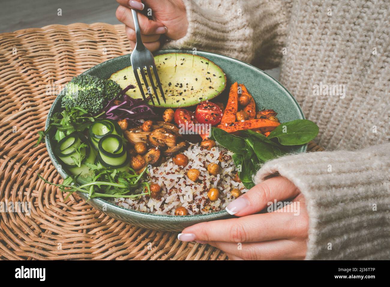 Donna che mangia una sana ciotola di buddha. Ciotola di Buddha con riso, quinoa, avocado e verdure Foto Stock