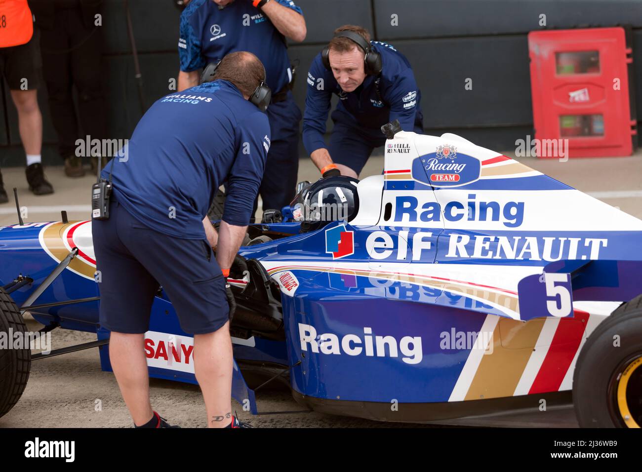 Damon Hill nell'abitacolo del Campionato del mondo che ha vinto la Formula uno Car FW18, circondato da membri del team Williams Racing Heritage, al Foto Stock