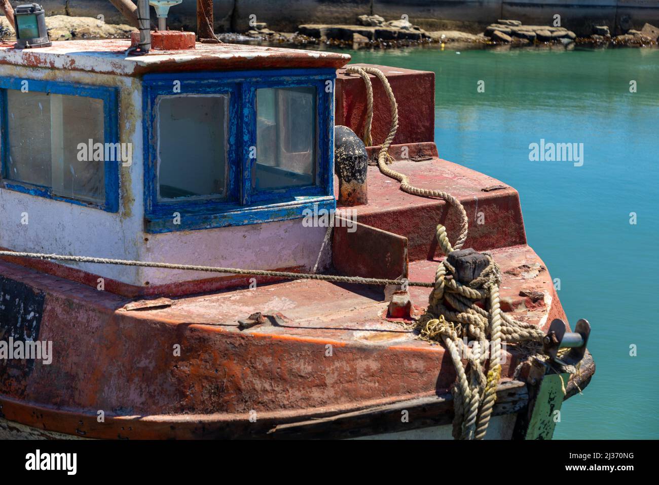 Cabina e prua di una vecchia barca inutilizzata e deteriorante in acqua. Foto Stock