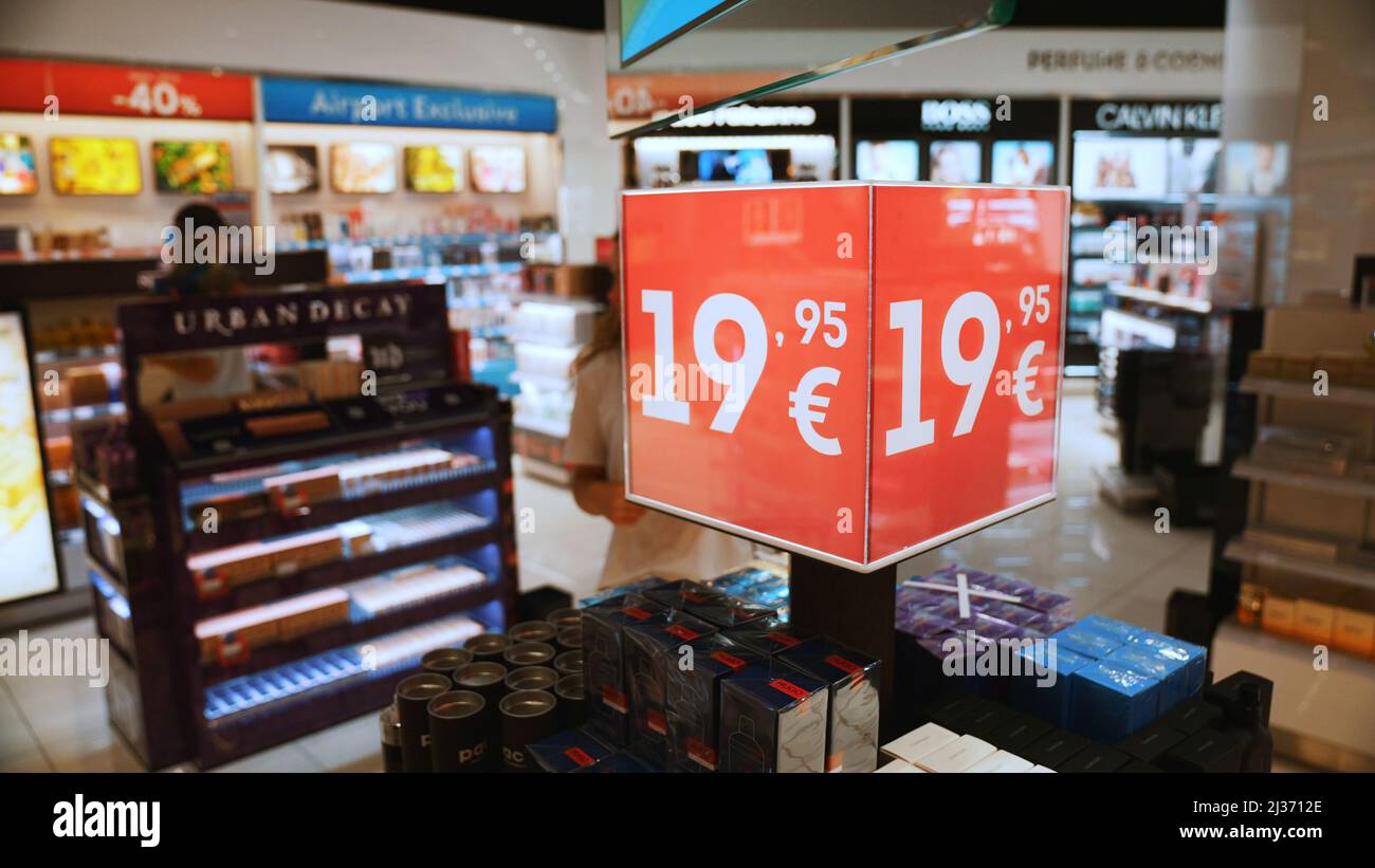 2021.08.18 Benidorm, Spagna un mercato illuminato con vetrine, scaffali, un sacco di merci, e un uomo con un tappo che guarda le merci. Foto di alta qualità Foto Stock