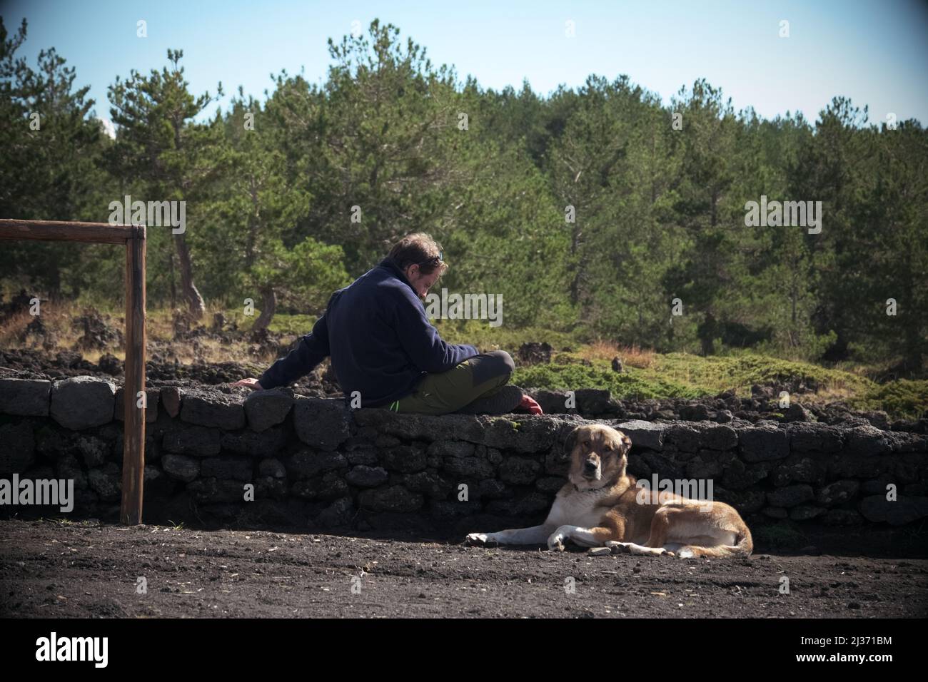 PARCO DELL'ETNA, SICILIA, ITALIA - 06 OTTOBRE 2018: L'uomo e il suo cane riposano in montagna Foto Stock