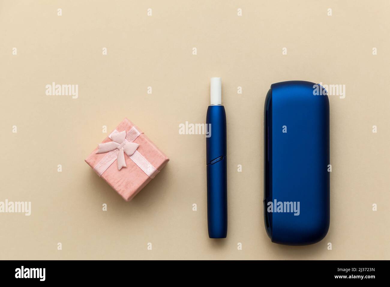 Sigaretta elettronica blu IQOS, con confezione regalo su sfondo beige Foto  stock