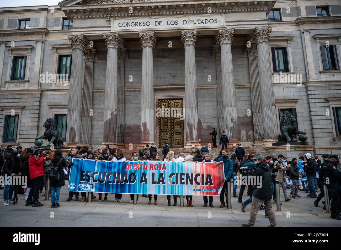 Madrid, Spagna. 06th Apr 2022. Gli attivisti dei cambiamenti climatici degli scienziati il gruppo di ribellione si vede protestare di fronte al Congresso dei deputati con una bandiera che legge 'allarme rosso, ascoltare la scienza'. Gli attivisti della ribellione scienziata, sostenuti dal gruppo della ribellione dell'estinzione, hanno condotto una protesta lanciando una vernice rossa all'ingresso del Congresso dei deputati facendo un atto pacifico di disobbedienza per denunciare l'inazione dei governi nella lotta al cambiamento climatico. Credit: Marcos del Maio/Alamy Live News Foto Stock