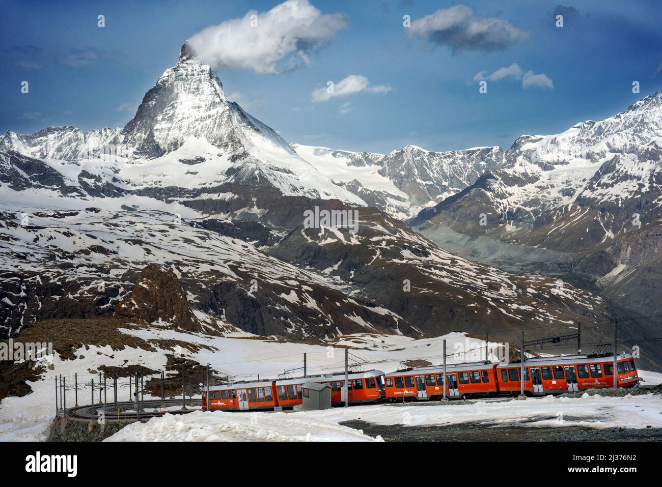 Un treno da Zermatt che si avvicina alla stazione di Gornergrat di fronte alla maestosa forma del Cervino, Vallese, Svizzera, Europa. Con la sua obse soleggiato Foto Stock