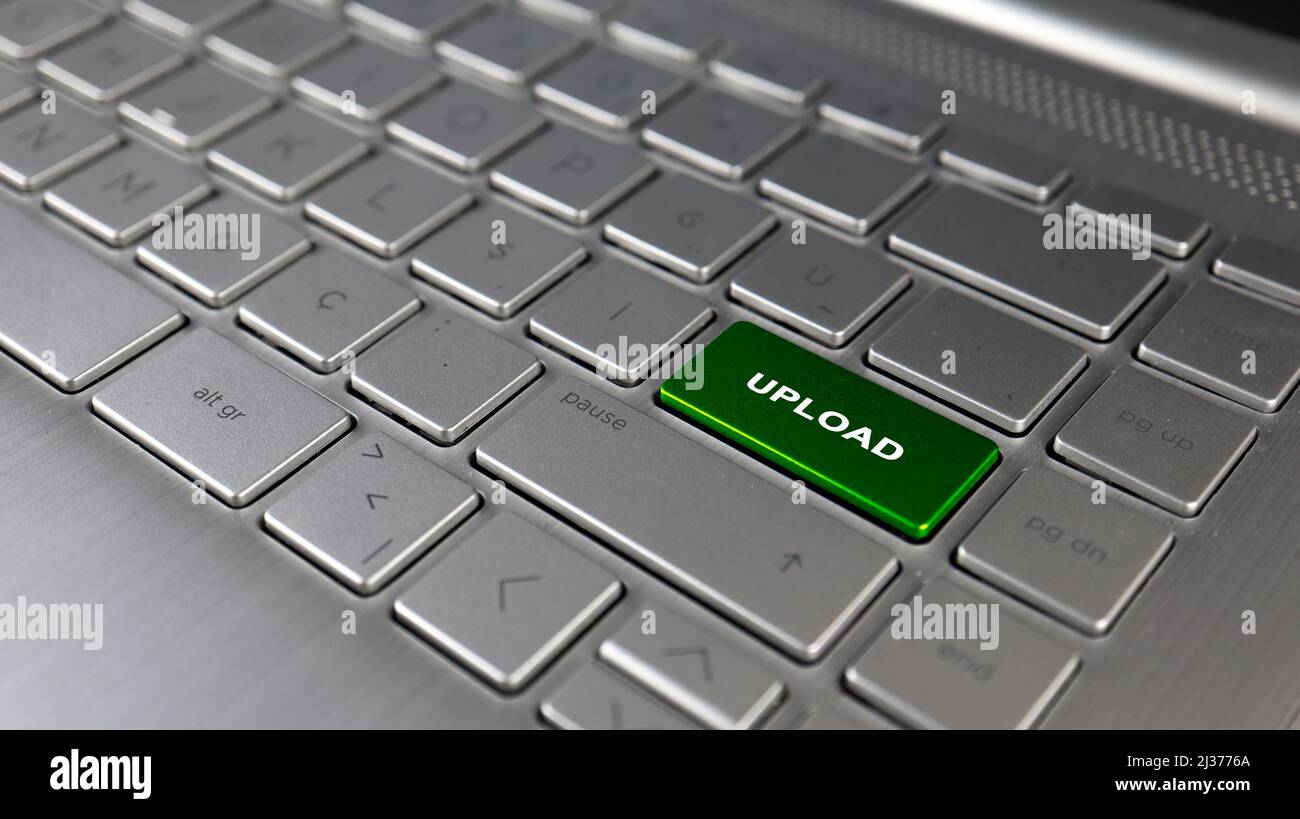 Tastiera con caricamento del testo sul pulsante invio, idea di caricamento dei file, concetto di termini del pc, primo piano della tastiera grigia, vista frontale, messa a fuoco selettiva Foto Stock