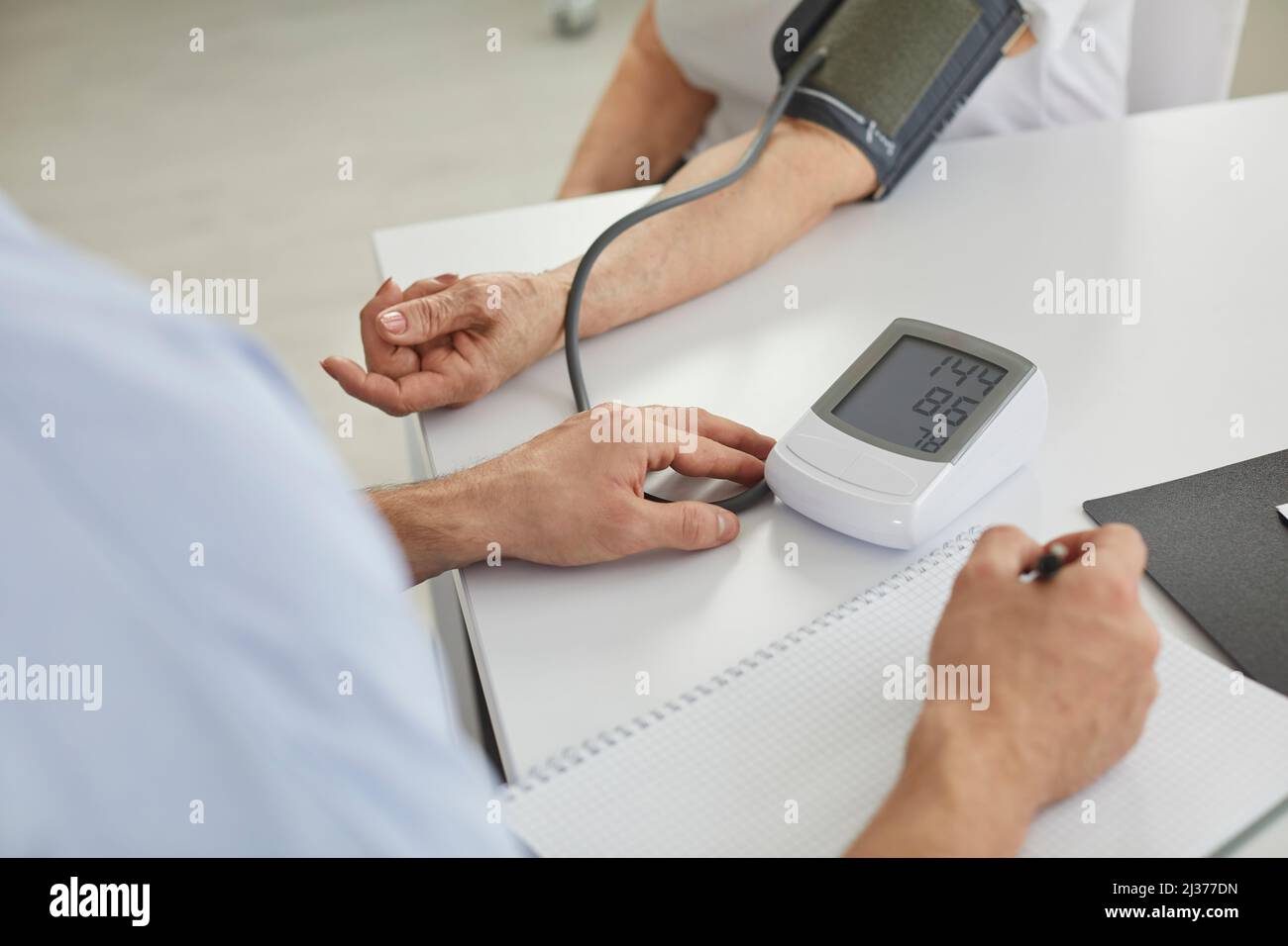 Il medico misura la pressione sanguigna delle donne anziane utilizzando un dispositivo di misurazione digitale elettronico. Foto Stock