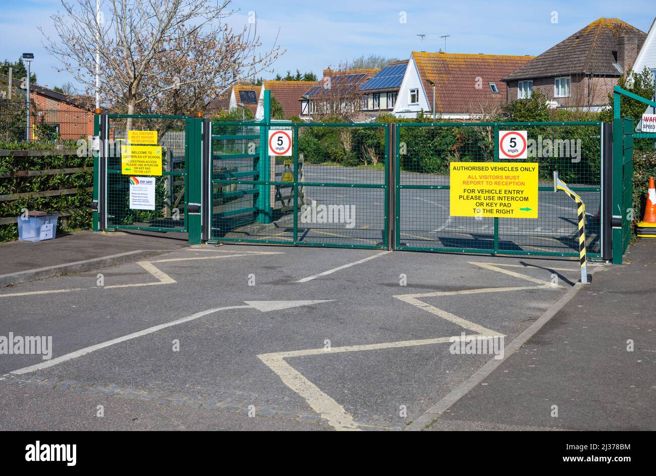 Porte chiuse e chiuse con chiusura a chiave della scuola solo con veicoli autorizzati e 5mph segnali di limite di velocità presso una scuola elementare in Inghilterra, Regno Unito. Foto Stock