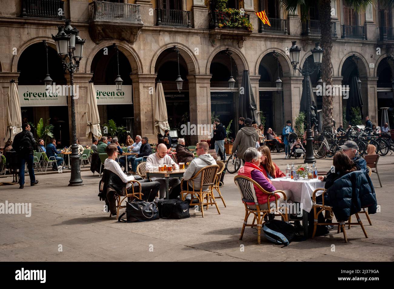 La gente si siede in una terrazza della Plaza Real di Barcellona. L'industria turistica di Barcellona prevede il 70% di occupazione alberghiera durante le vacanze della settimana Santa e quindi avvicinarsi al numero di visitatori pre-pandemici. Foto Stock