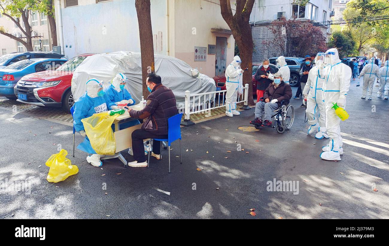 SHANGHAI, CINA - 6 APRILE 2022 - Un operatore medico esegue un test sugli acidi nucleici per una persona anziana con mobilità limitata a Shanghai, Cina, aprile Foto Stock