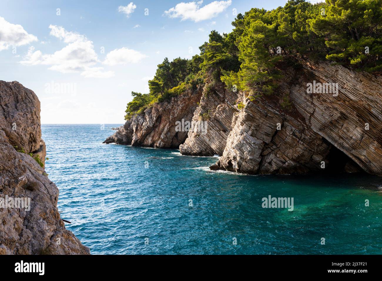 Mare e rocce Clifs in città Petrovac, Montenegro. Foto Stock