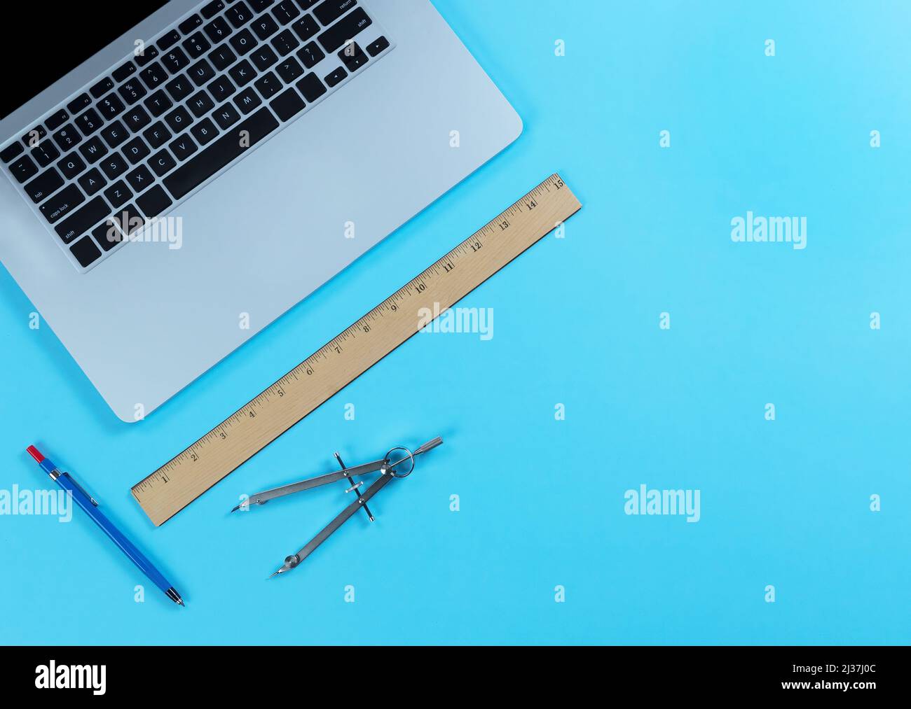 Desktop blu con strumenti di progettazione di architetti composti da righello, matita meccanica, computer portatile e bussola. Foto Stock