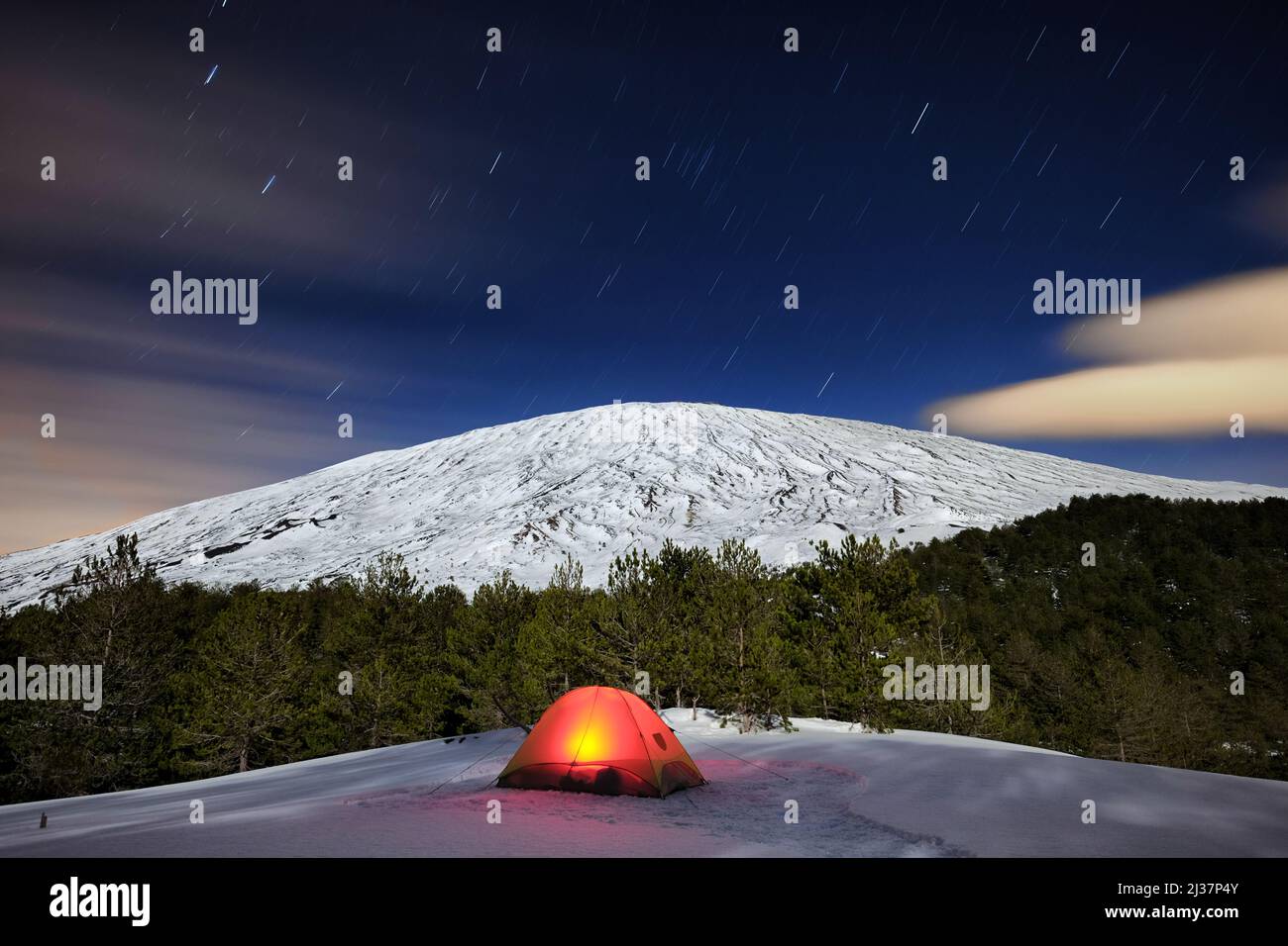 Tenda illuminata sotto l'Etna d'inverno e sentieri stellari, Sicilia Foto Stock