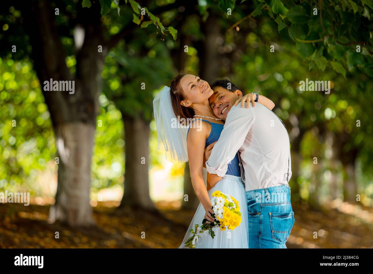 Ritratto di una giovane coppia in abito da sposa che celebra il loro anniversario di matrimonio. Sorridi, bacia, amore. Foto Stock