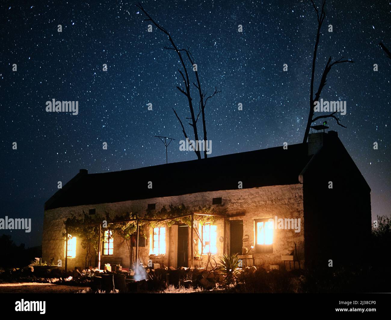 Segui la luce fino al ritorno a casa. Foto di una casa in campagna in una notte stellata e scura. Foto Stock