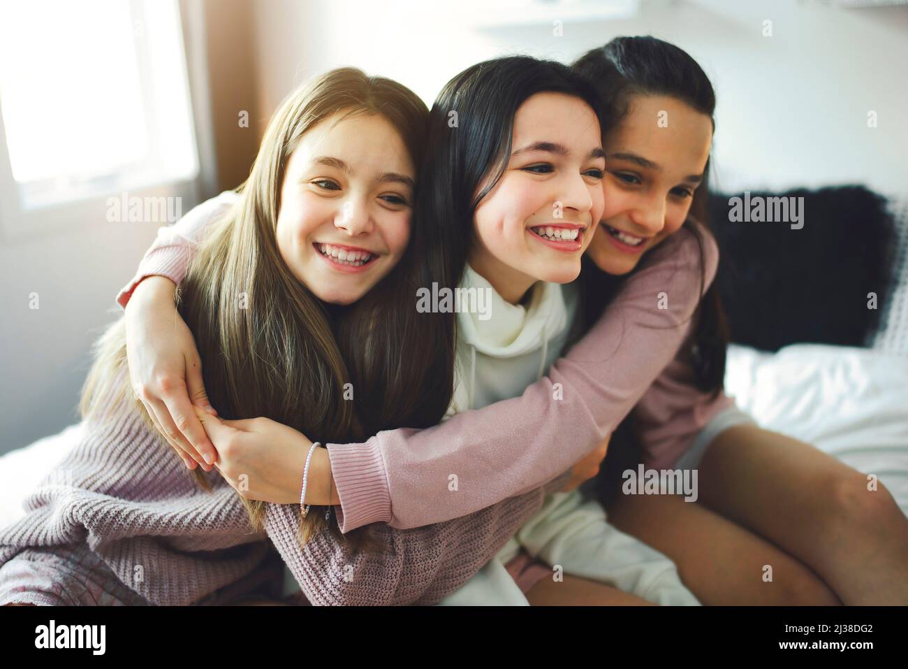 Tre ragazze adolescenti eccitate che si divertono insieme, godendo il tempo libero oziato a casa Foto Stock