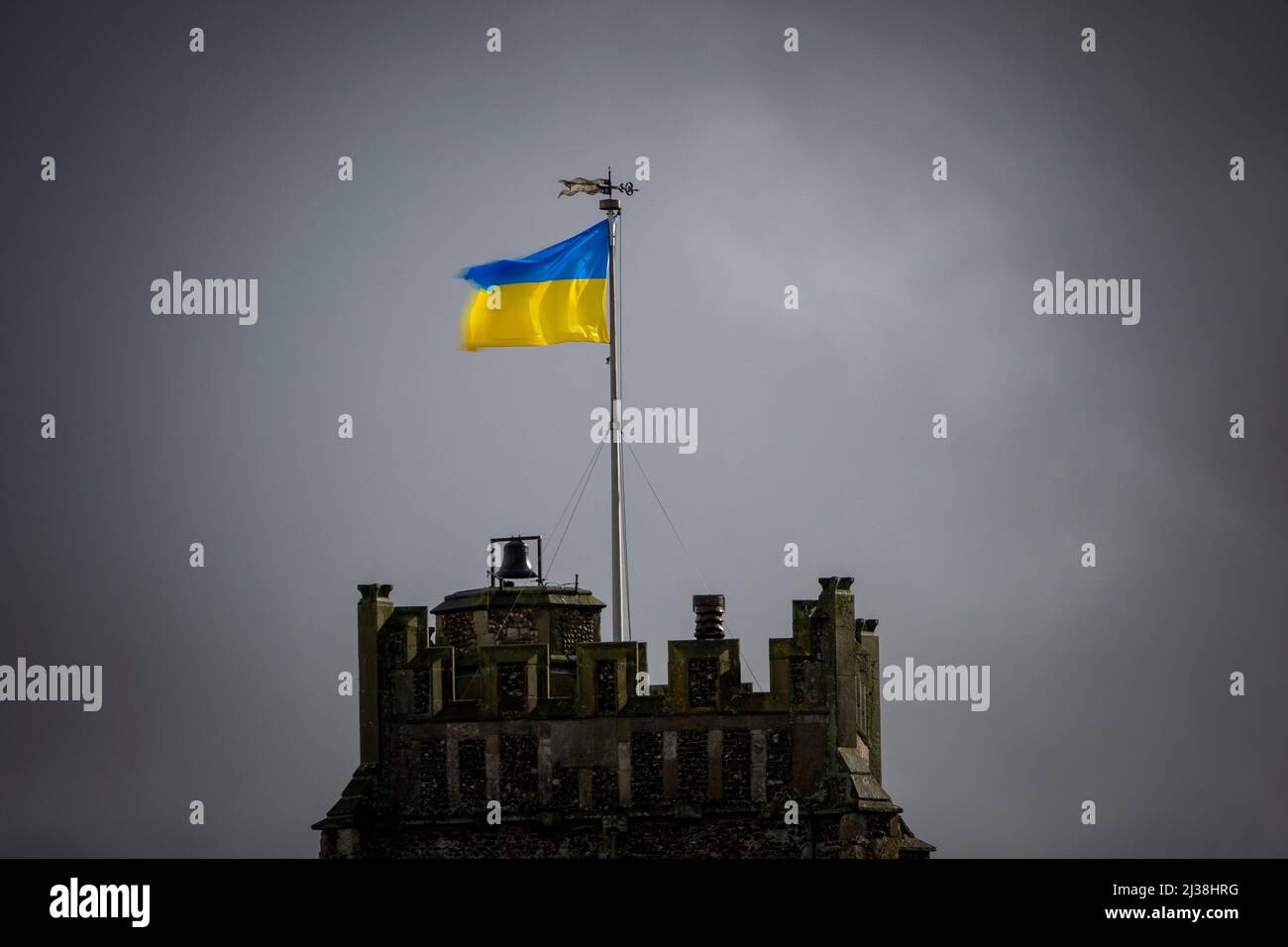 La bandiera bicolore della Repubblica popolare Ucraina che vola dalla torre della chiesa di San Pietro e San Paolo, Aldeburgh, Suffolk, durante una tempesta di tuoni. Foto Stock